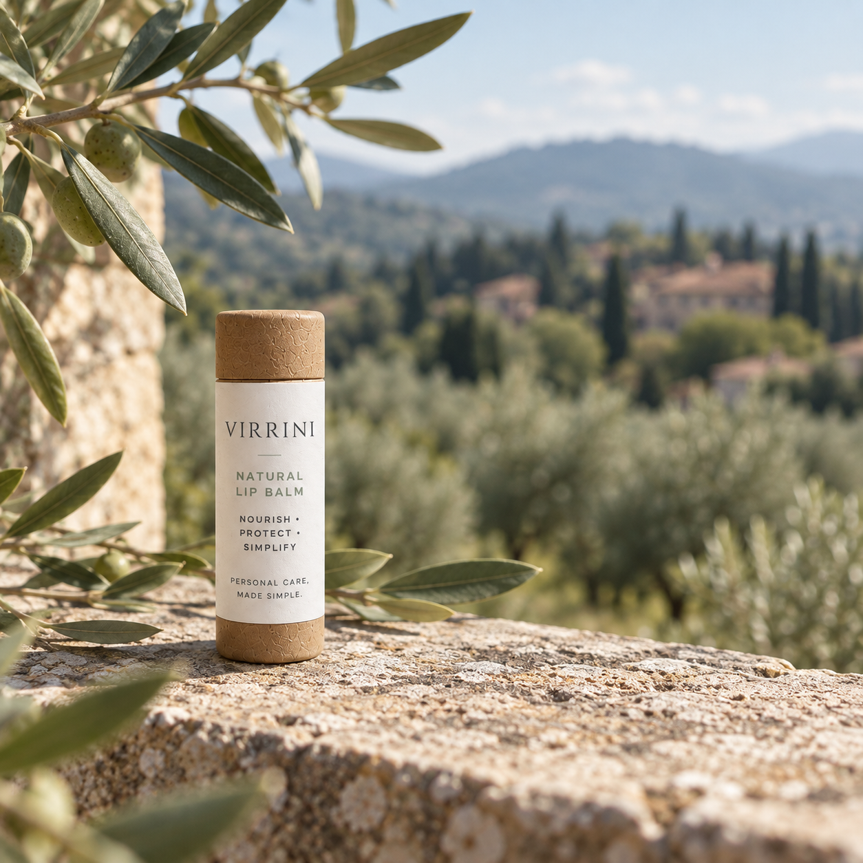 Concept image of Virrini lip balm among olive branches and hills inspired by the landscape around Lucca